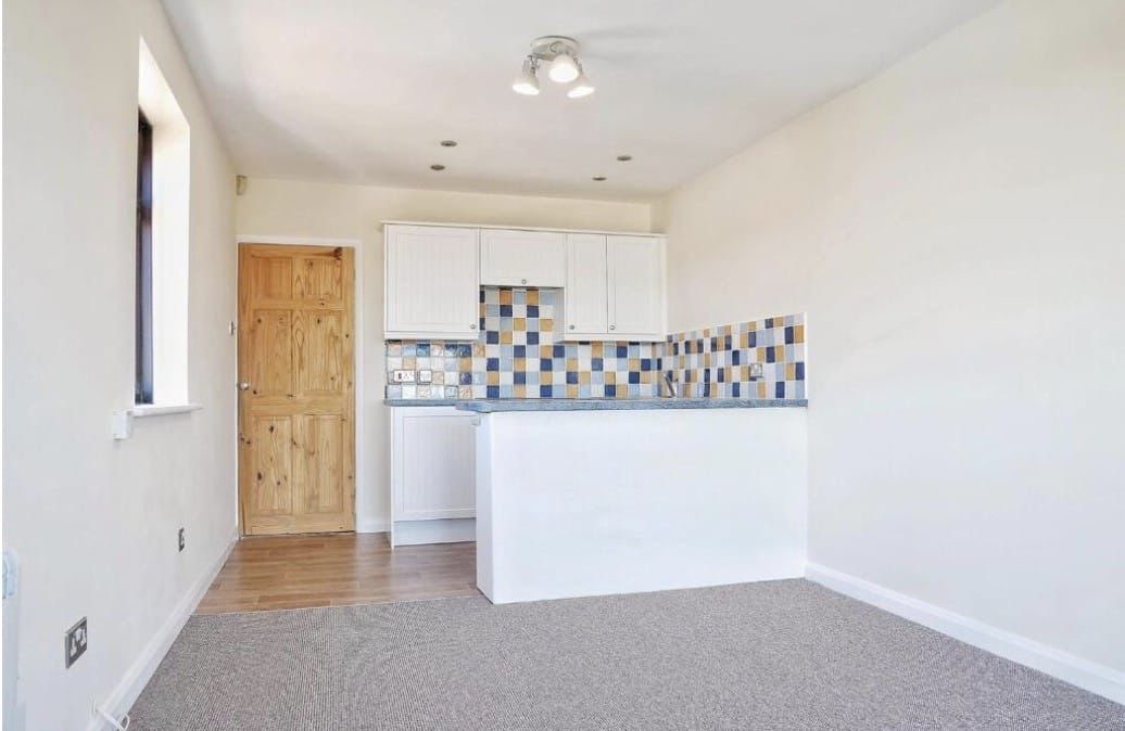 Dated kitchen before renovation with tiled splashback and carpet